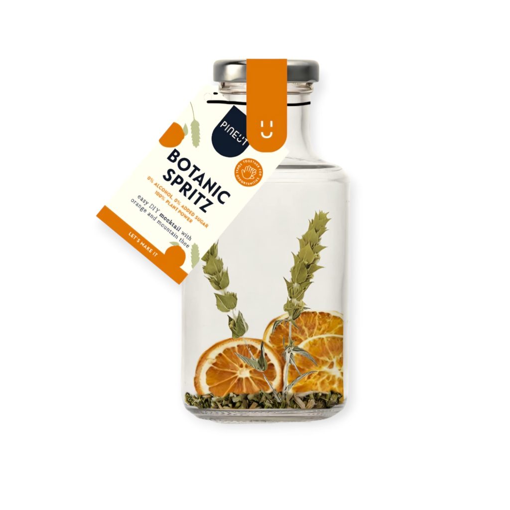Mocktail fles en glas met sinaasappel en kruideninfusie voor mindful genieten
